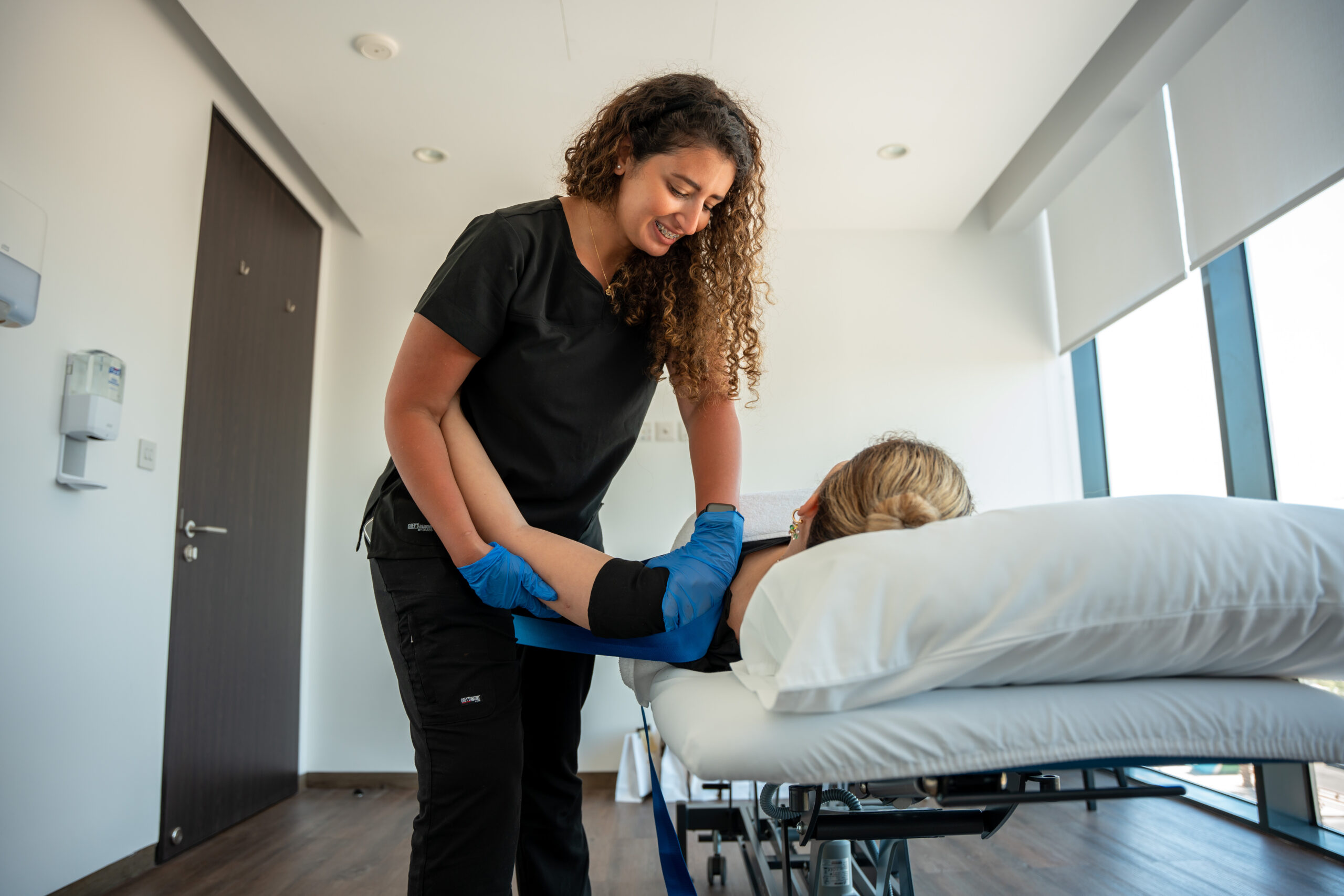 Physiotherapist guiding a patient's arm rehabilitation exercise