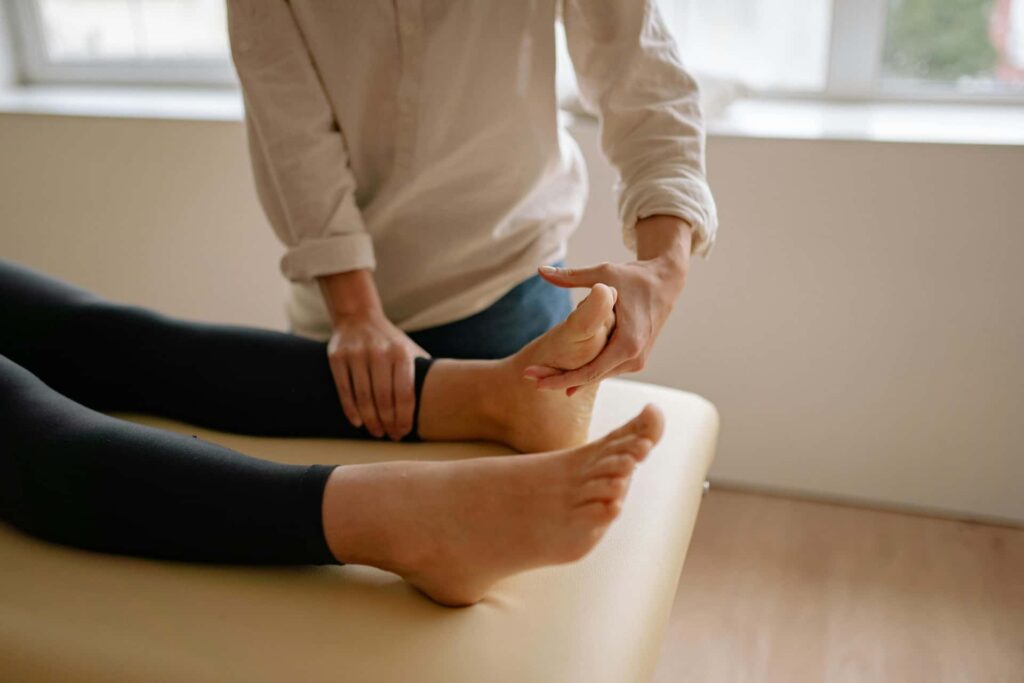 Therapist examining a patient's swollen foot and ankle